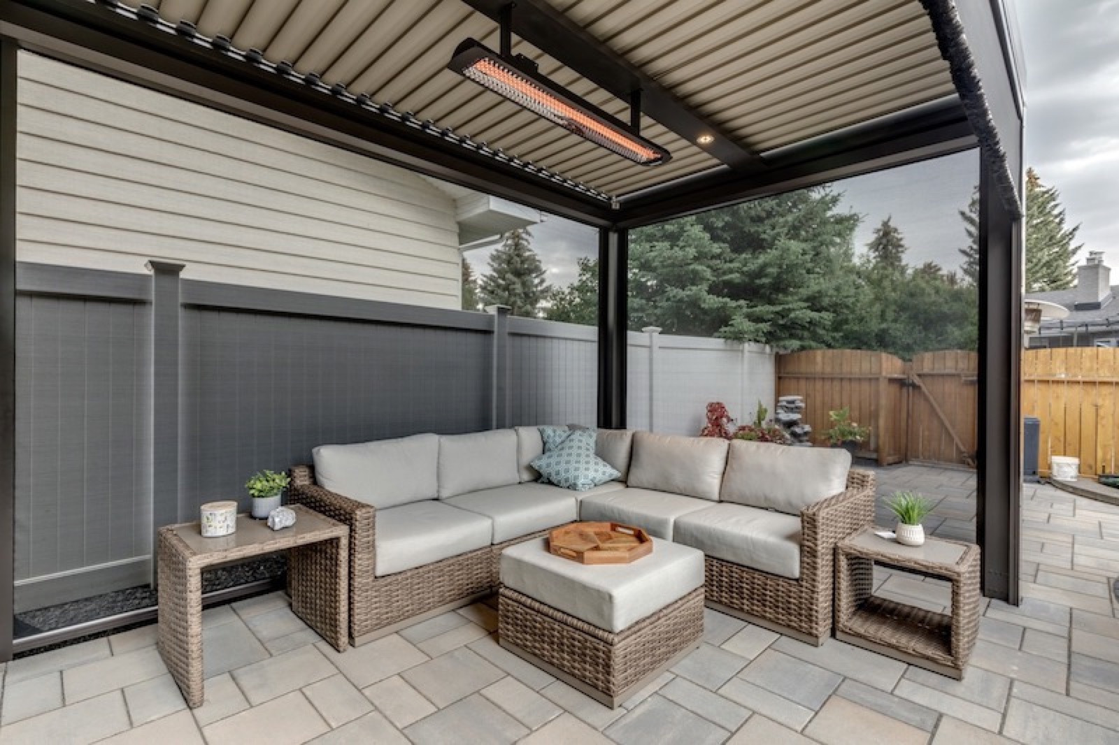 An overhead patio heater mounted beneath a louvered roof