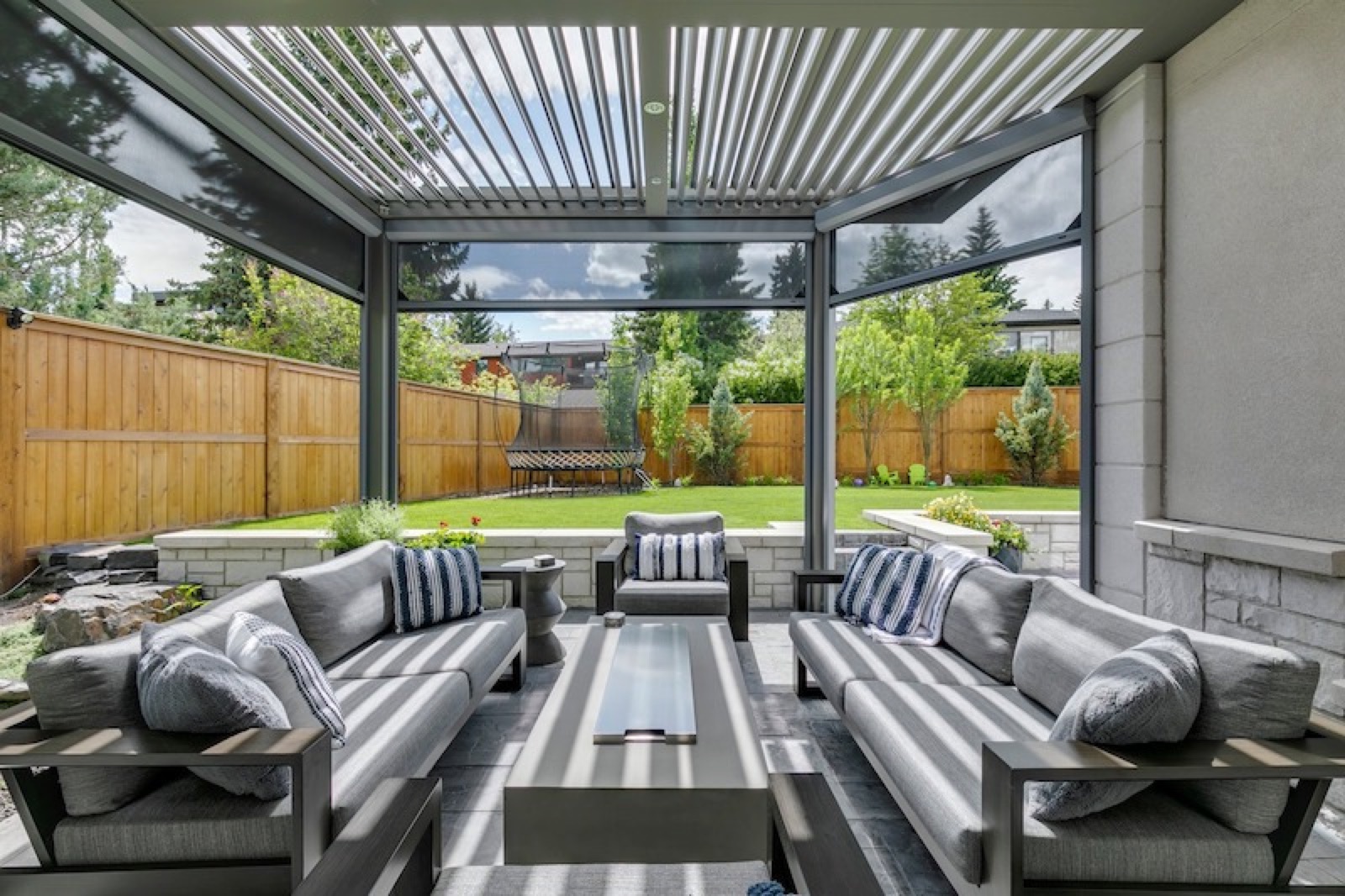 Screened outdoor living space opening toward a green lawn